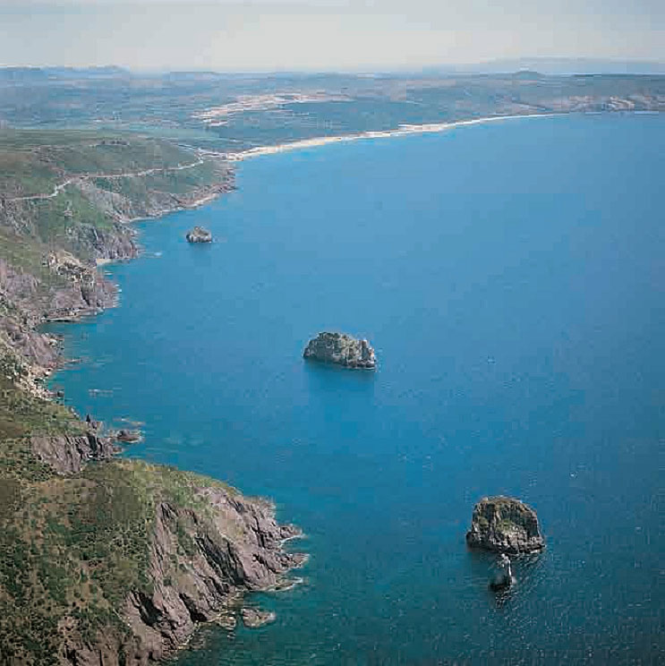 Gli scogli di s’Agusteri e del Morto. Sullo sfondo la spiaggia di Funtanamare